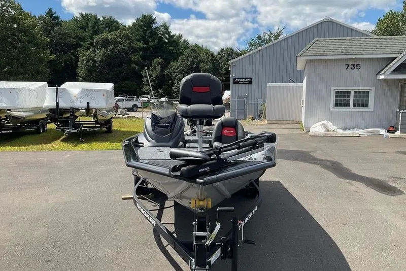 Slide: The Image of 2025 Tracker Pro Team 175 boat parked outside dealership, surrounded by trees and trailers. - 8