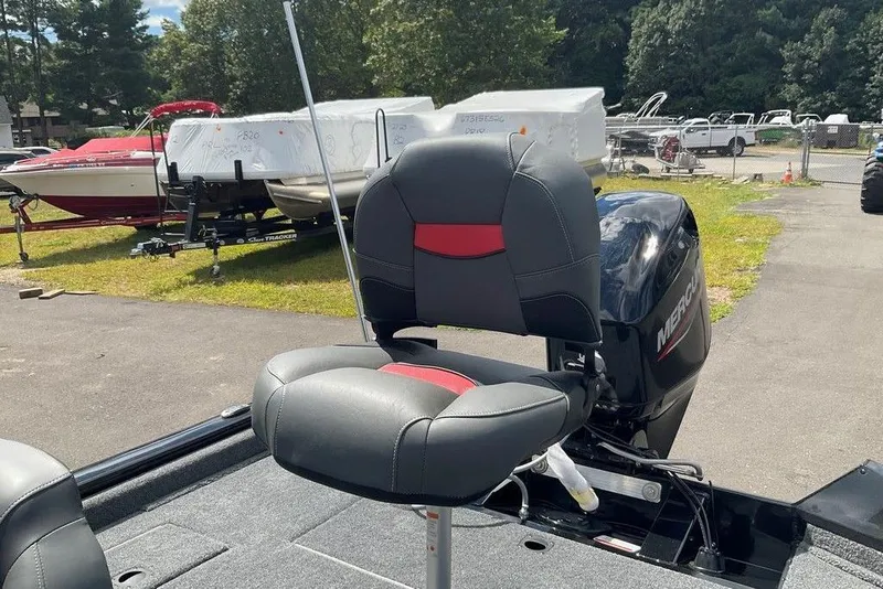 Slide: The Image of 2025 Tracker Pro Team 175 boat seat with Mercury engine in a boatyard. - 9