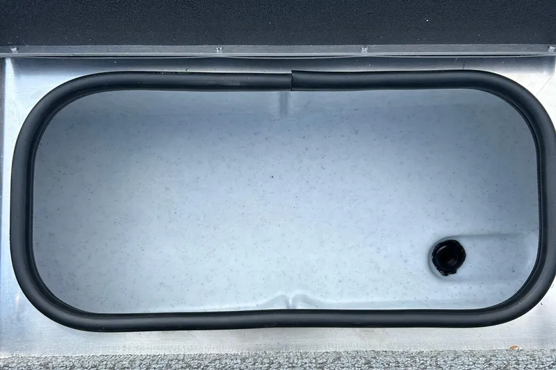 Slide: The Image of Livewell compartment in 2026 Lund 2075 Alaskan Sport boat, featuring a drain plug. - 14