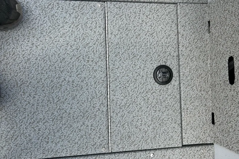 Slide: The Image of 2026 Lund 2075 Alaskan Sport boat deck with textured surface and storage compartment. - 16