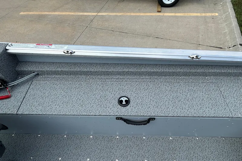 Slide: The Image of 2026 Lund 2075 Alaskan Sport boat interior with storage compartment and textured flooring. - 18