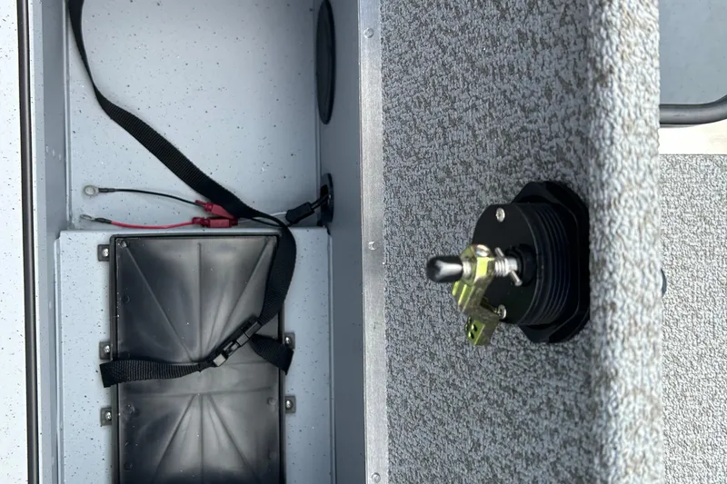 Slide: The Image of Interior view of 2026 Lund 2075 Alaskan Sport boat showing battery compartment and switch. - 21