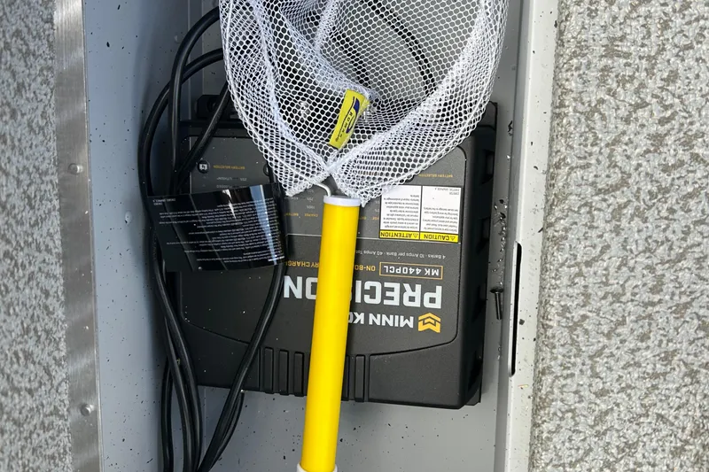 Slide: The Image of Fishing net and battery charger in Lund 2075 Alaskan Sport boat compartment, 2026 model. - 27