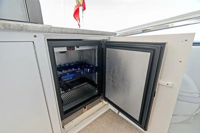 Slide: The Image of Open mini fridge on 2011 Westport yacht, stocked with beverages, under a countertop. - 28