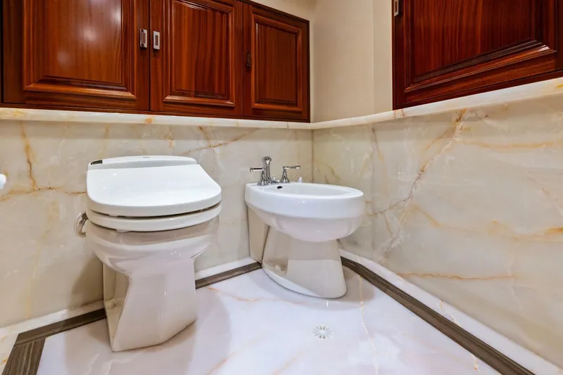 Slide: The Image of Luxurious bathroom with marble walls, wooden cabinets, toilet, and bidet in a 2011 Westport model. - 51