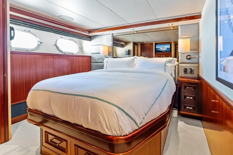 Slide: The Image of Luxurious bedroom interior on a 2011 Westport yacht, featuring elegant wood paneling and plush bedding. - 57