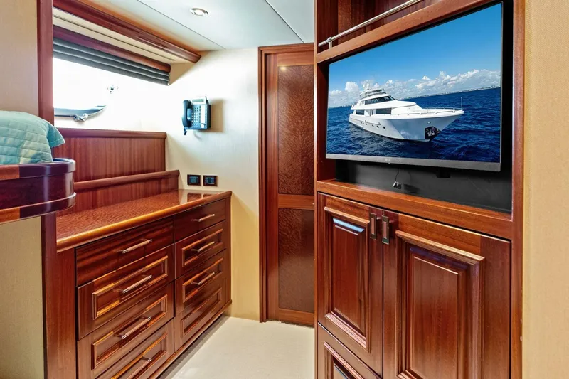 Slide: The Image of Luxurious 2011 Westport yacht interior with wood cabinetry and wall-mounted TV displaying yacht image. - 62