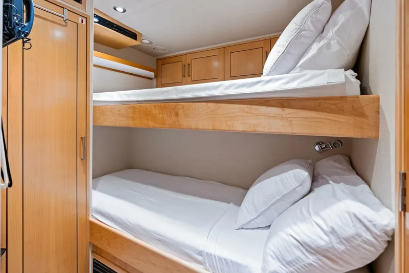 Slide: The Image of Bunk beds in a 2011 Westport yacht cabin with wooden cabinetry and white bedding. - 77
