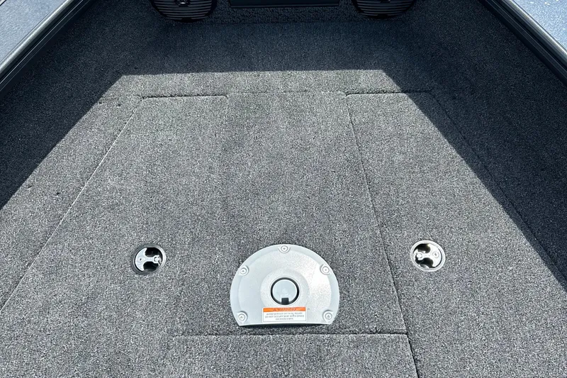 Slide: The Image of 2026 Lund 1875 Crossover XS boat interior with carpeted flooring and storage compartments. - 22