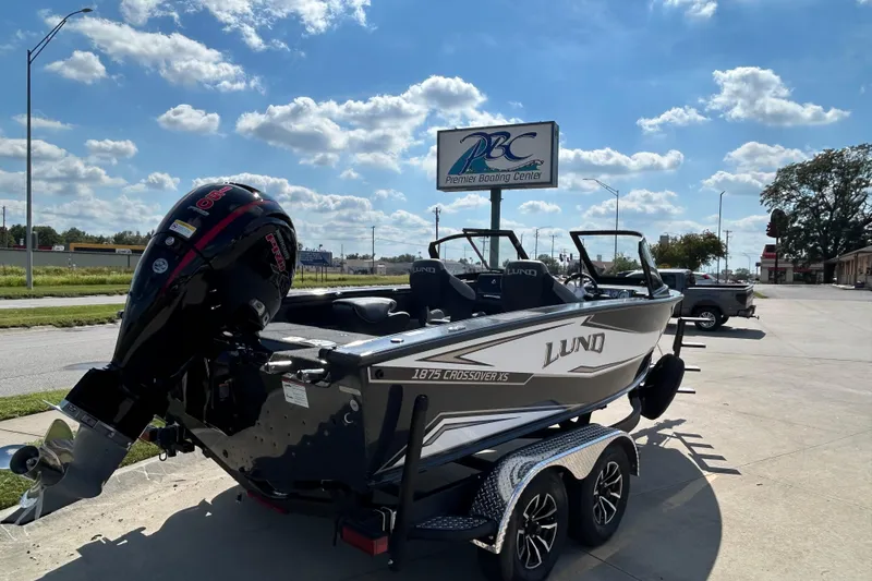 Slide: The Image of 2026 Lund 1875 Crossover XS boat at Premier Boating Center under a sunny sky. - 3