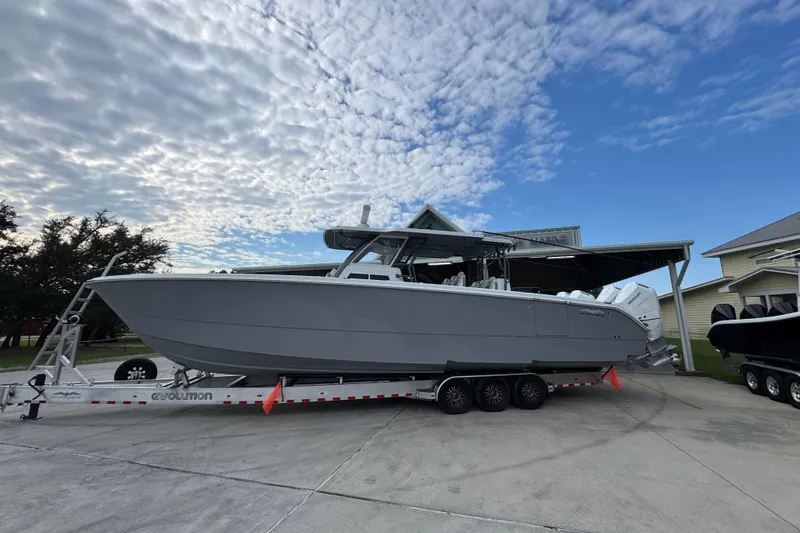 The Image of 2026 Invincible 40 Catamaran on trailer under cloudy sky, parked near buildings. - 1