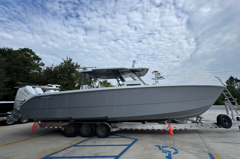 Slide: The Image of 2026 Invincible 40 Catamaran on trailer, parked outdoors under cloudy sky. - 10