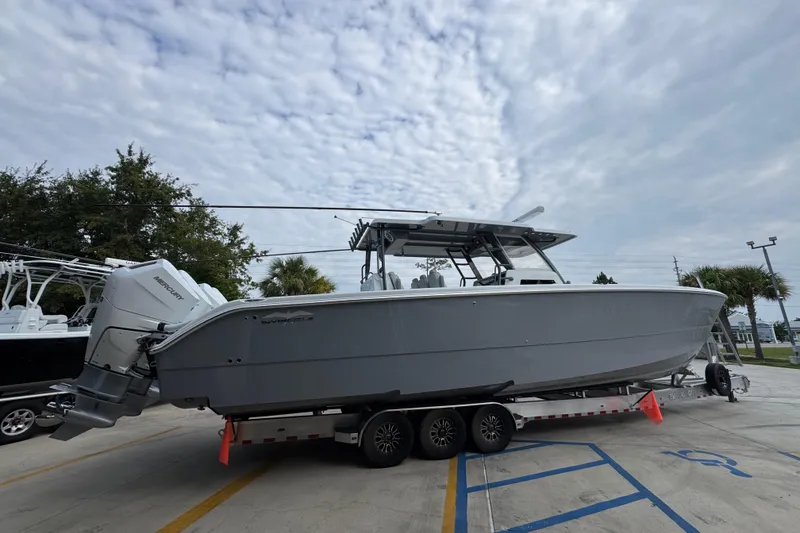Slide: The Image of 2026 Invincible 40 Catamaran on trailer, parked outdoors under cloudy sky. - 11