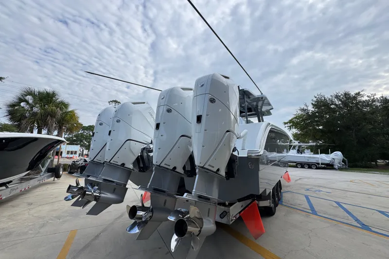 Slide: The Image of 2026 Invincible 40 Catamaran with powerful outboard engines, parked outdoors under a cloudy sky. - 13