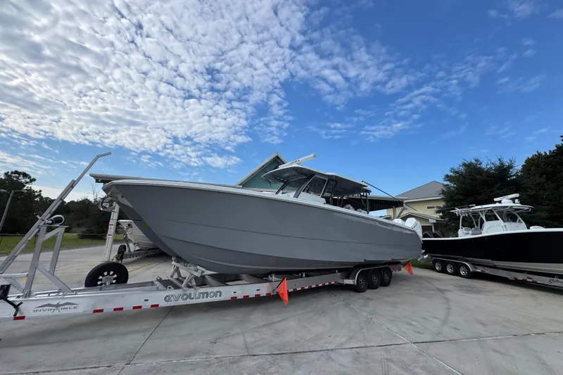 Slide: The Image of 2026 Invincible 40 Catamaran on trailer under a partly cloudy sky. - 3