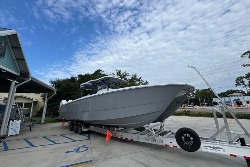Slide: The Image of 2026 Invincible 40 Catamaran on trailer, parked outdoors under a partly cloudy sky. - 8