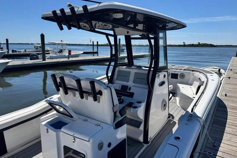 Slide: The Image of 2022 Tidewater 280 CC Adventure boat docked, featuring modern helm and seating. - 2