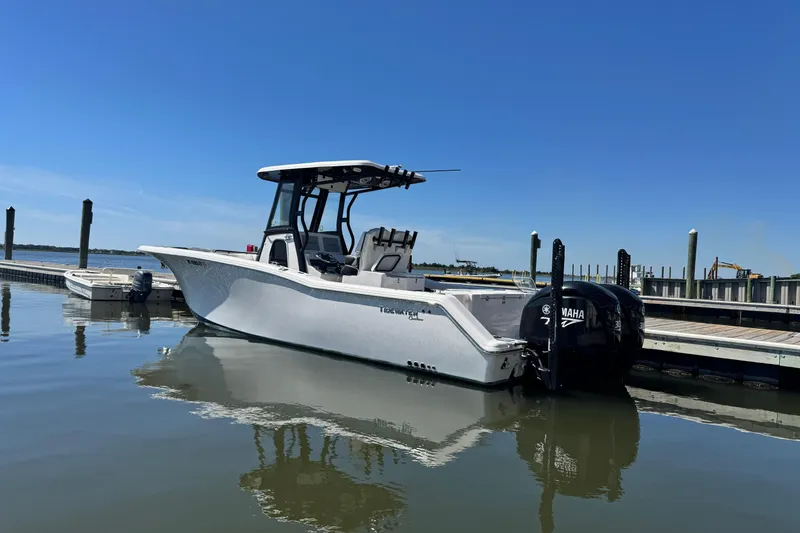 Slide: The Image of 2022 Tidewater 280 CC Adventure boat docked with twin Yamaha engines. - 7