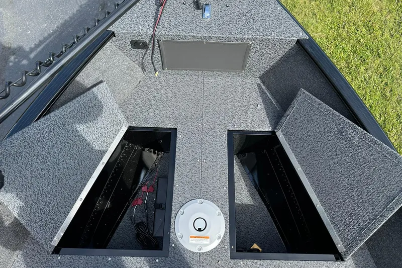 Slide: The Image of 2026 Lund 1650 Rebel XL Sport boat interior with open storage compartments. - 12