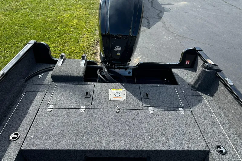 Slide: The Image of 2026 Lund 1650 Rebel XL Sport boat interior with motor and storage compartments. - 16