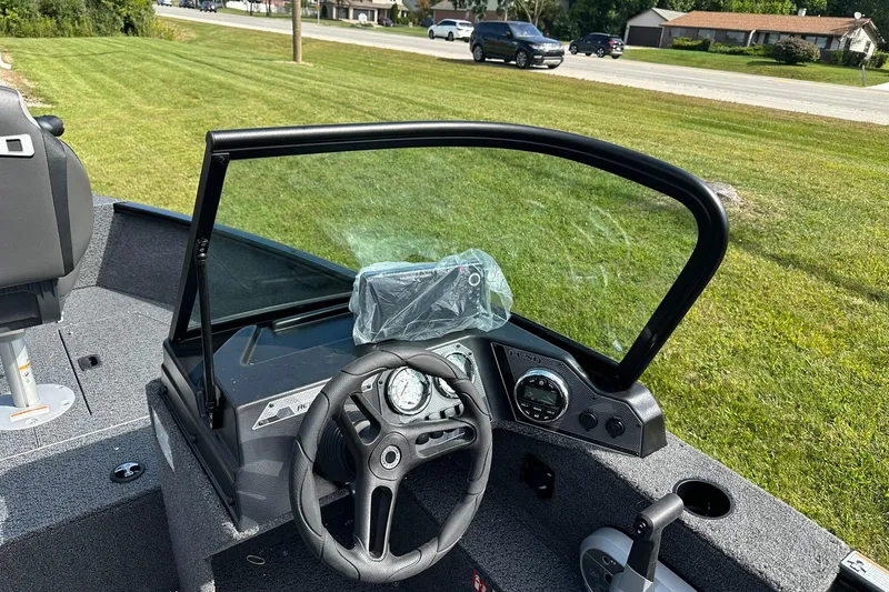 Slide: The Image of 2026 Lund 1650 Rebel XL Sport boat dashboard with steering wheel and controls. - 17