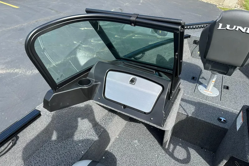 Slide: The Image of 2026 Lund 1650 Rebel XL Sport boat interior with windshield and seating. - 18