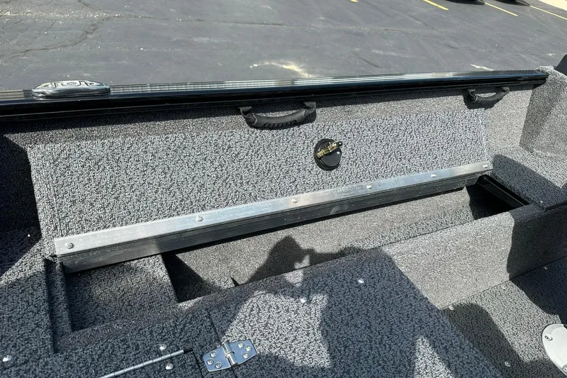 Slide: The Image of 2026 Lund 1650 Rebel XL Sport boat interior storage compartment with textured finish. - 21