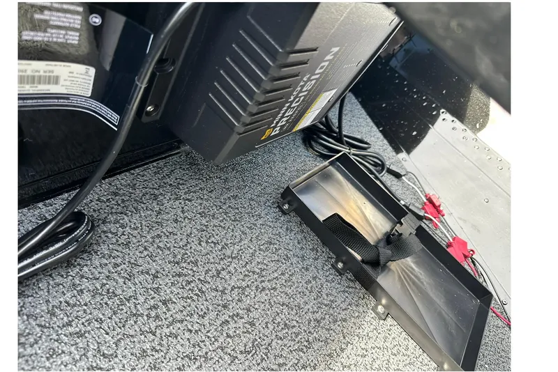 Slide: The Image of 2026 Lund 1650 Rebel XL Sport boat interior with battery charger and cables. - 24