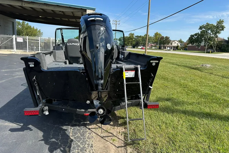 Slide: The Image of 2026 Lund 1650 Rebel XL Sport boat with outboard motor and ladder on grass. - 5