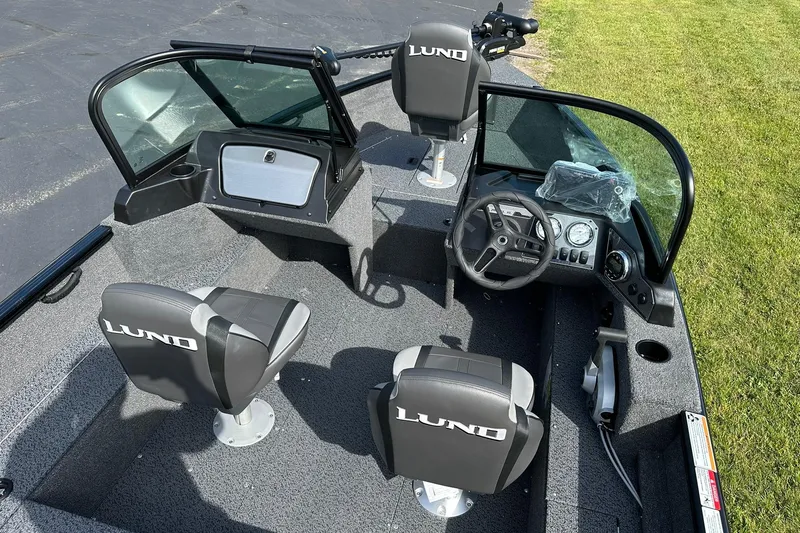 Slide: The Image of 2026 Lund 1650 Rebel XL Sport boat interior with steering console and seating. - 7