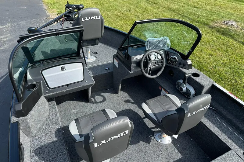 Slide: The Image of 2026 Lund 1650 Rebel XL Sport boat interior with seating and steering console. - 8