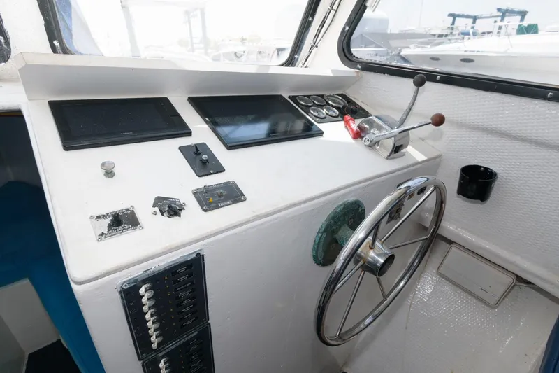 Slide: The Image of 1997 Evans 36 Deadrise boat helm with steering wheel and control panel. - 11