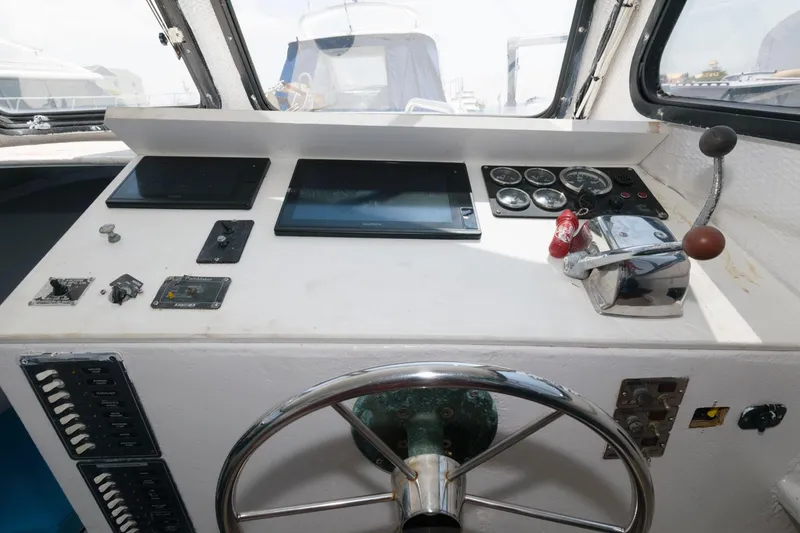 Slide: The Image of Steering console of a 1997 Evans 36 Deadrise boat with gauges and controls. - 12