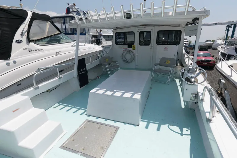 Slide: The Image of 1997 Evans 36 Deadrise boat deck with seating and helm, docked among other vessels. - 4