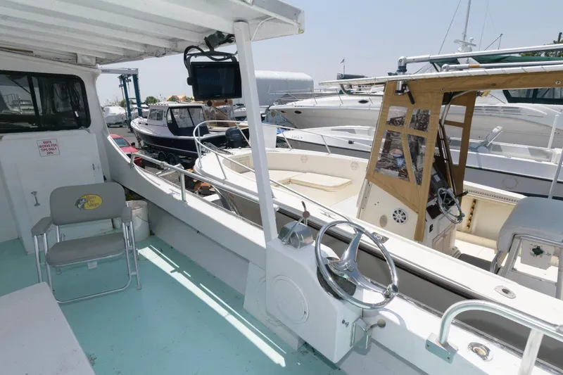 Slide: The Image of 1997 Evans 36 Deadrise boat interior with steering wheel and docked vessels. - 6