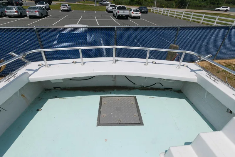 Slide: The Image of 1997 Evans 36 Deadrise boat deck with railing, parked near a lot with cars. - 8
