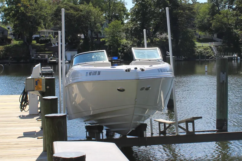 The Image of 2013 Rinker Captiva 246 BR boat docked on a sunny day by the water. - 0