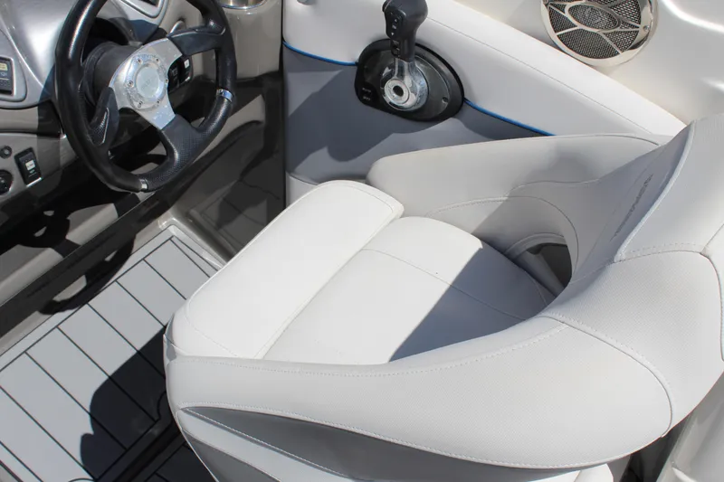 Slide: The Image of 2013 Rinker Captiva 246 BR boat interior with steering wheel and white seating. - 5