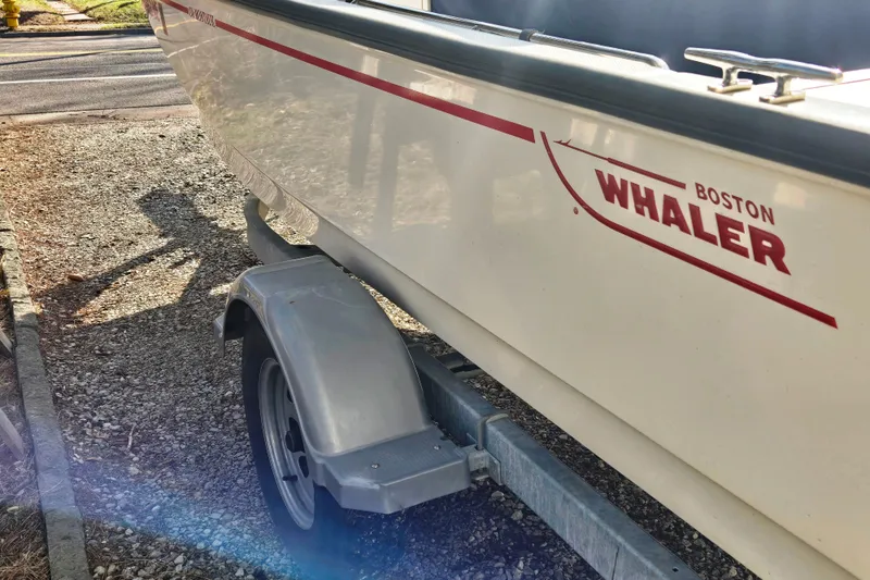 Slide: The Image of 2021 Boston Whaler 17MTK boat on trailer, side view with logo visible. - 2