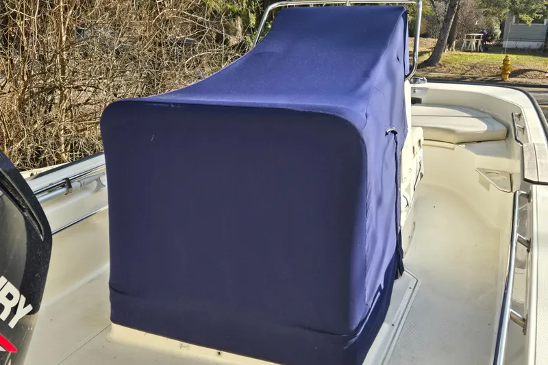 Slide: The Image of 2021 Boston Whaler 17MTK boat with blue console cover, parked outdoors. - 4