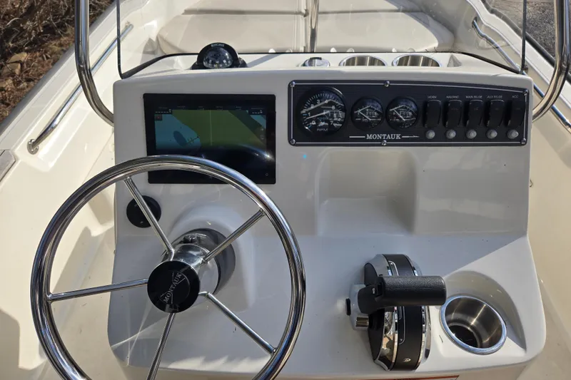 Slide: The Image of 2021 Boston Whaler 17MTK boat dashboard with steering wheel and control panel. - 5