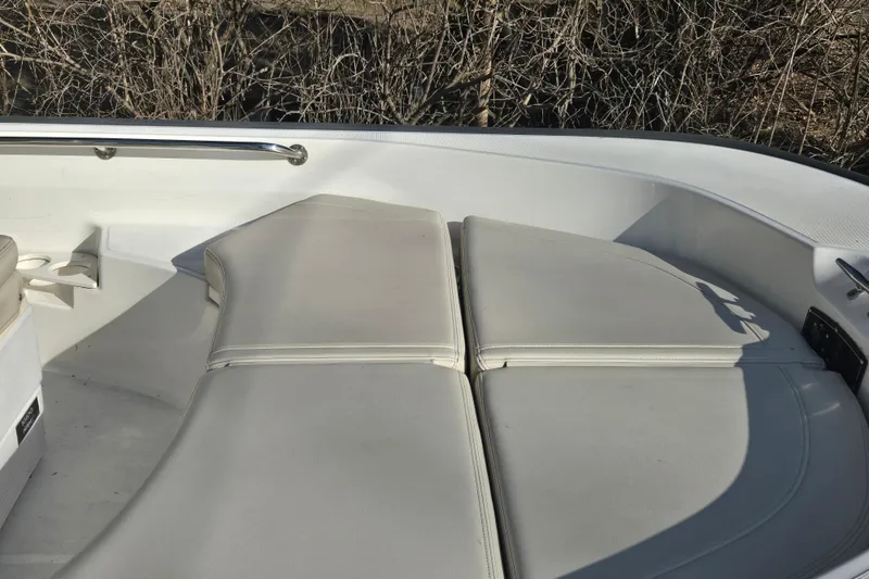 Slide: The Image of 2021 Boston Whaler 17MTK boat interior with cushioned seating and stainless steel railing. - 7