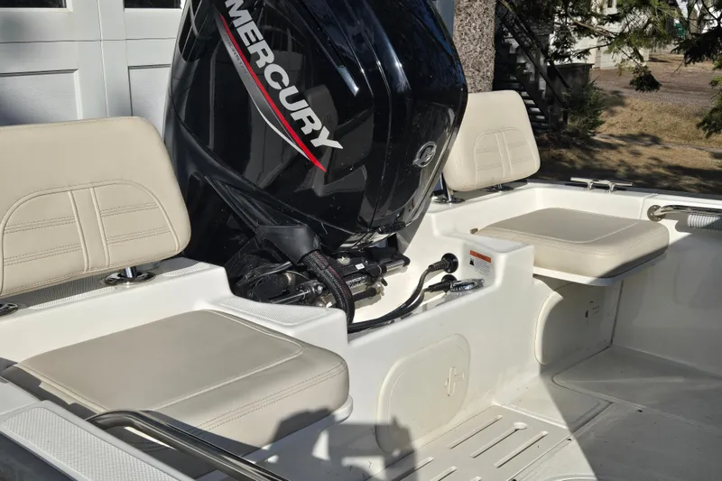 Slide: The Image of 2021 Boston Whaler 17MTK boat interior with Mercury engine and beige seating. - 9