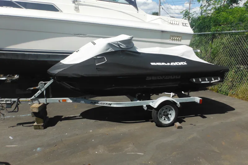 The Image of 2016 Sea-Doo GTX Limited 300 jet ski covered on trailer, parked outdoors. - 0