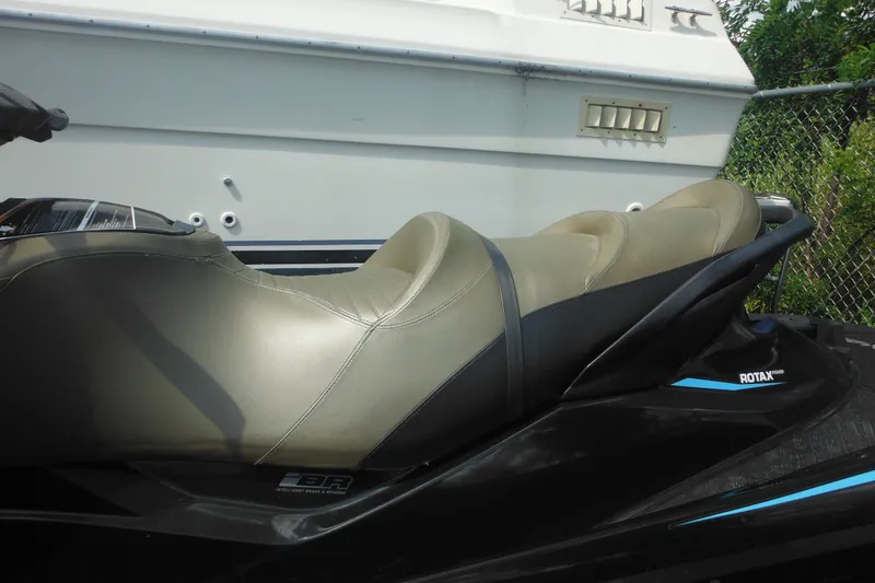 Slide: The Image of 2016 Sea-Doo GTX Limited 300 jet ski with beige seating, parked near a boat. - 11