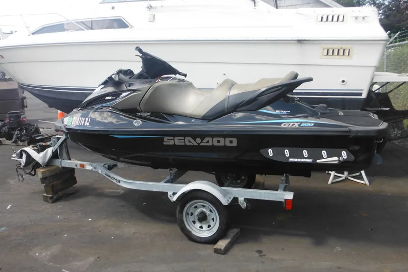 Slide: The Image of 2016 Sea-Doo GTX Limited 300 jet ski on trailer, parked beside a larger boat. - 7