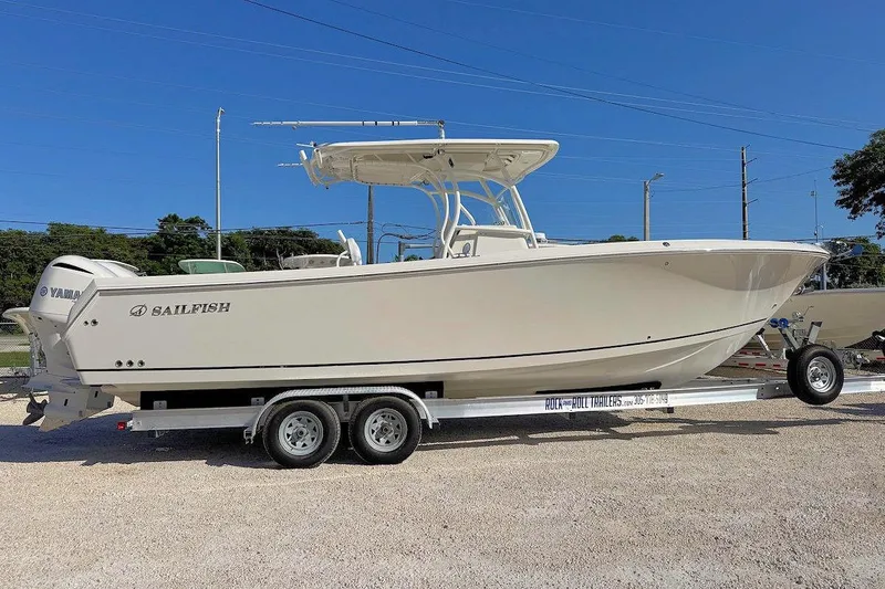 Slide: The Image of 2013 Sailfish 290 CC boat on trailer, side view, clear blue sky background. - 1