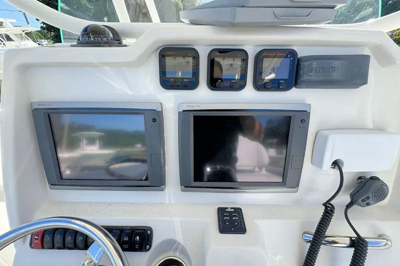Slide: The Image of Control panel of a 2013 Sailfish 290 CC boat with navigation screens and instruments. - 11