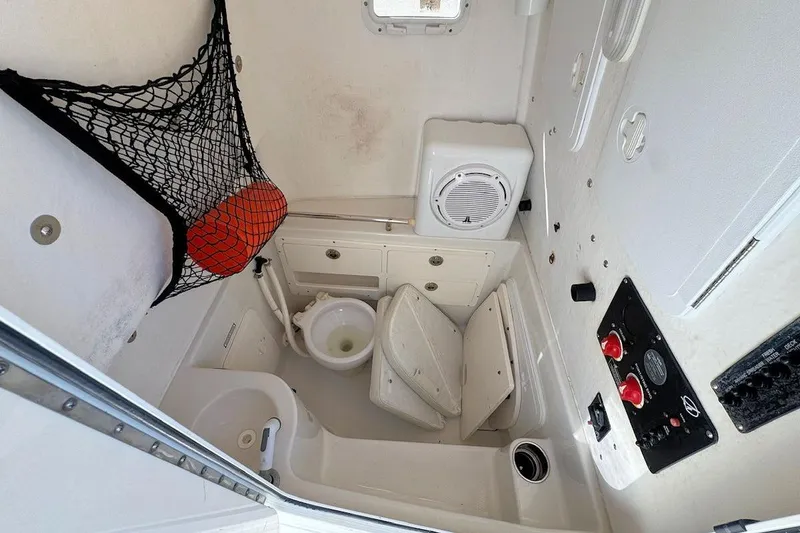 Slide: The Image of 2013 Sailfish 290 CC boat interior with toilet, storage, and control panel. - 12