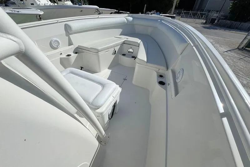 Slide: The Image of 2013 Sailfish 290 CC boat interior with white seating and storage compartments. - 14